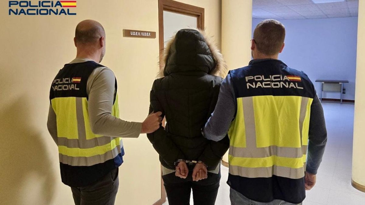 Dos agentes de la Policía Nacional deteniendo a una persona.
