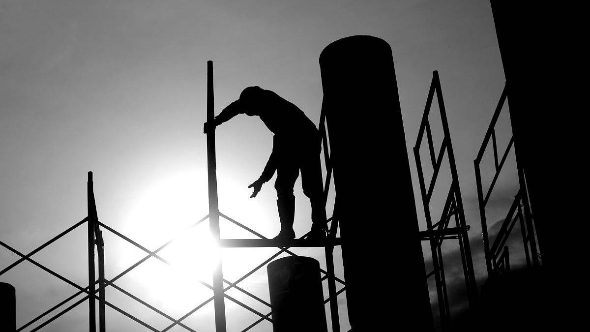 Un operario de la construcción trabaja subido a un andamio.
