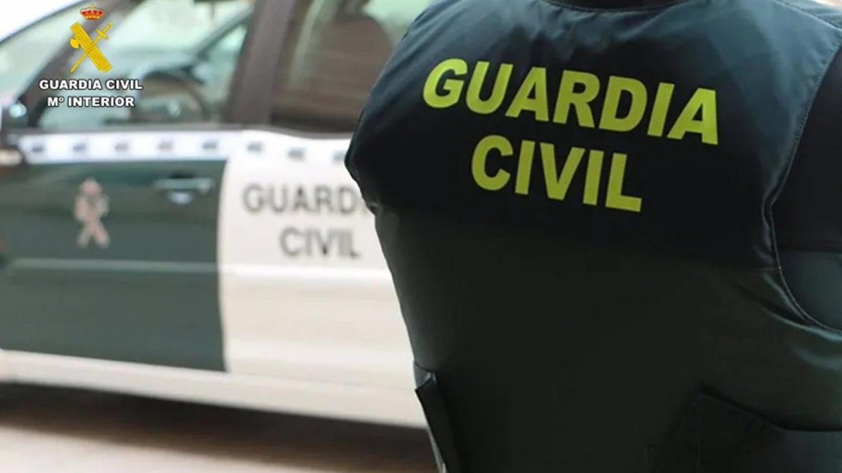 Imagen de archivo de un agente de la Guardia Civil junto a un vehículo oficial.