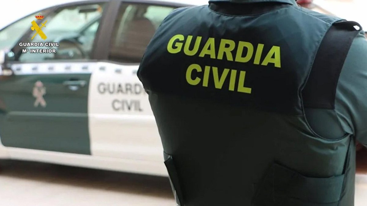 Un agente de la Guardia Civil junto a un vehículo oficial.