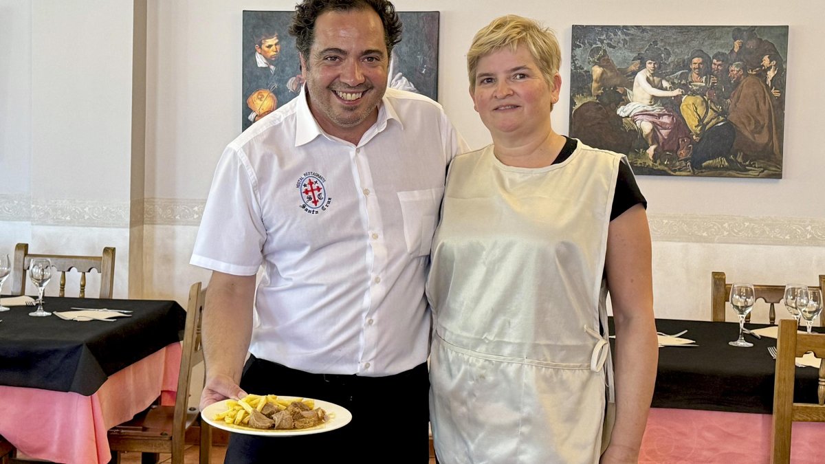 Francisco y Ana María, en el comedor del restaurante Santa Cruz, con las réplicas de los cuadros a su espalda.