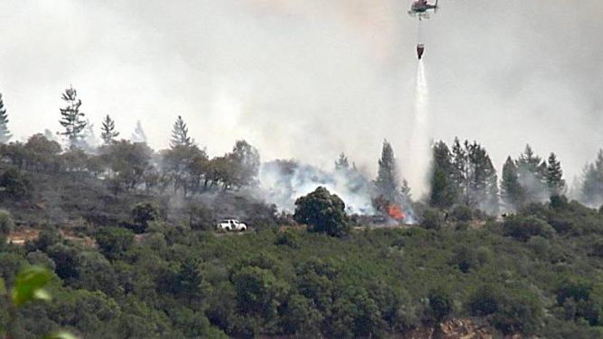 Un helicóptero trabaja en las tareas de extinción de un incendio en Congosto, en El Bierzo (León).