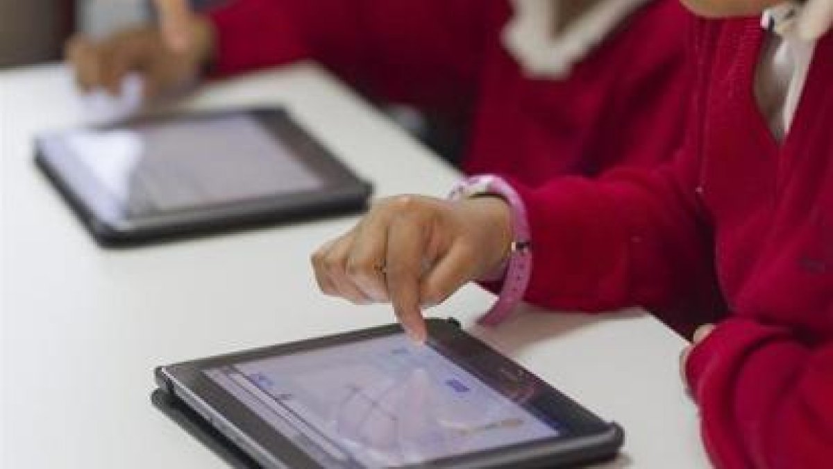 Alumnos emplean tablets en una clase.