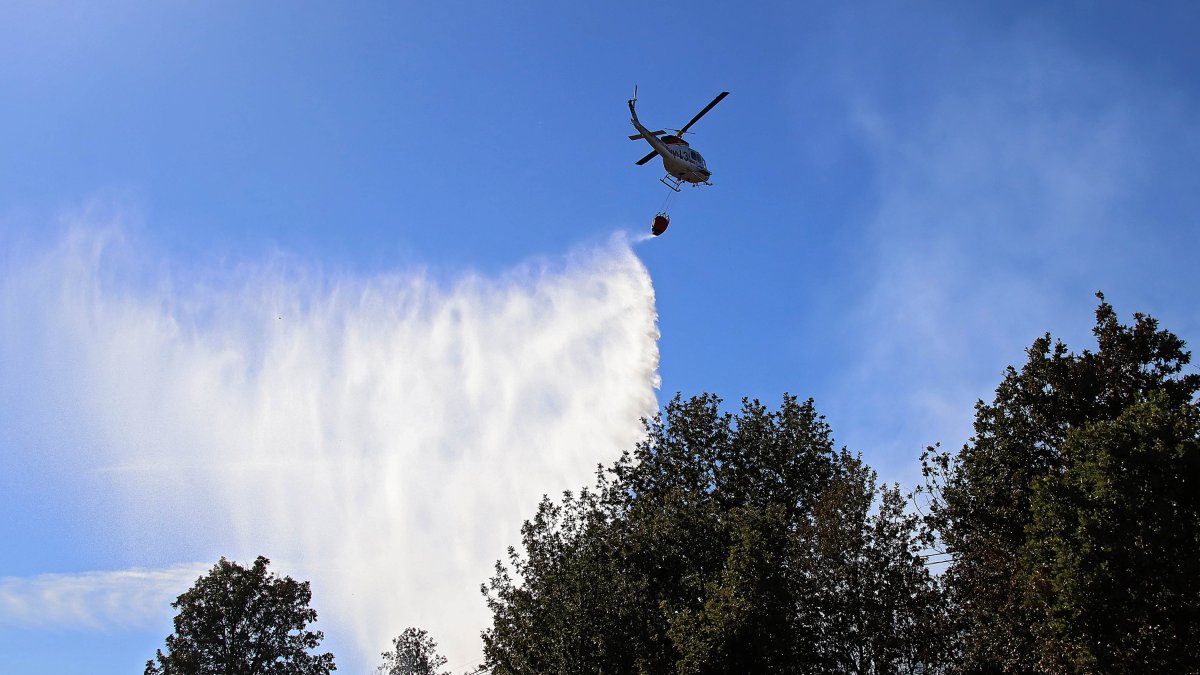 Medios terrestres y aéreos trabajan en la extinción de un incendio en San Andrés del Rabanedo (León).- ICAL