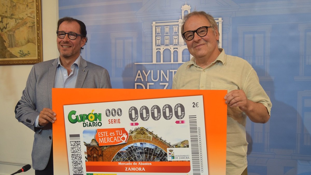 El concejal de Turismo Comercio y OMD del Ayuntamiento de Zamora, Christoph Karl Albert Kaspar, y el delegado territorial de la ONCE en Castilla y León, Ismael Pérez, presentan el cupón dedicado al Mercado de Abastos de la capital zamorana, perteneciente a la serie 
