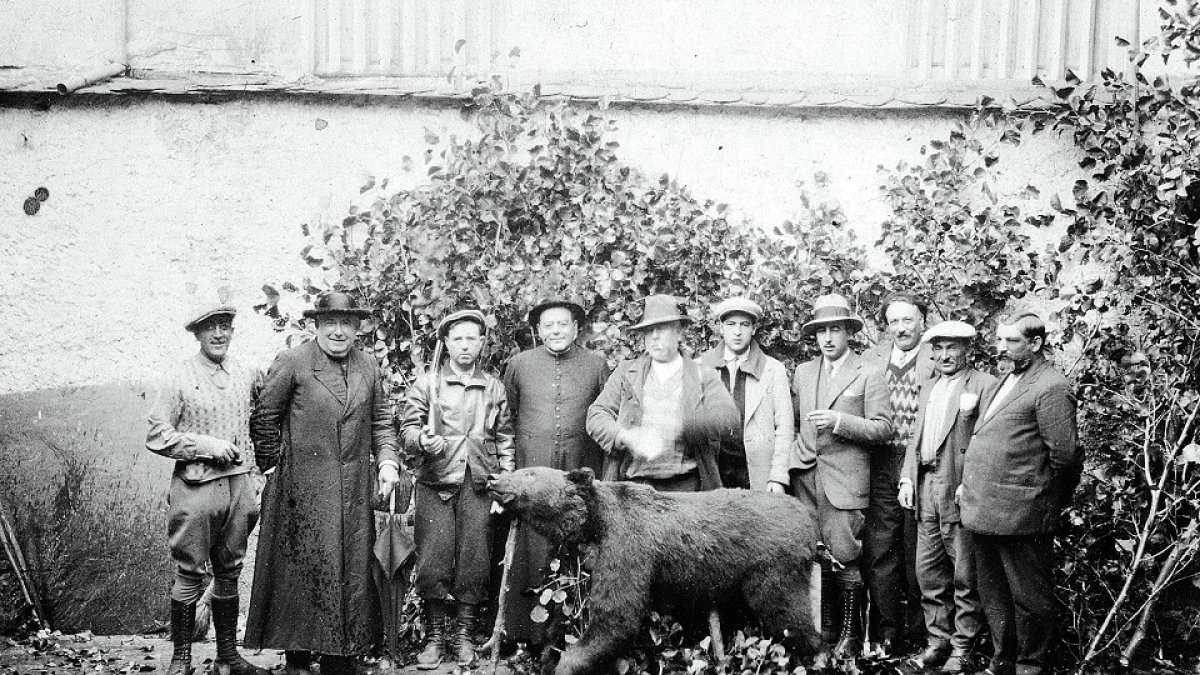 El párroco y el juez municipal, entre otros socios del coto, con un oso pardo abatido.