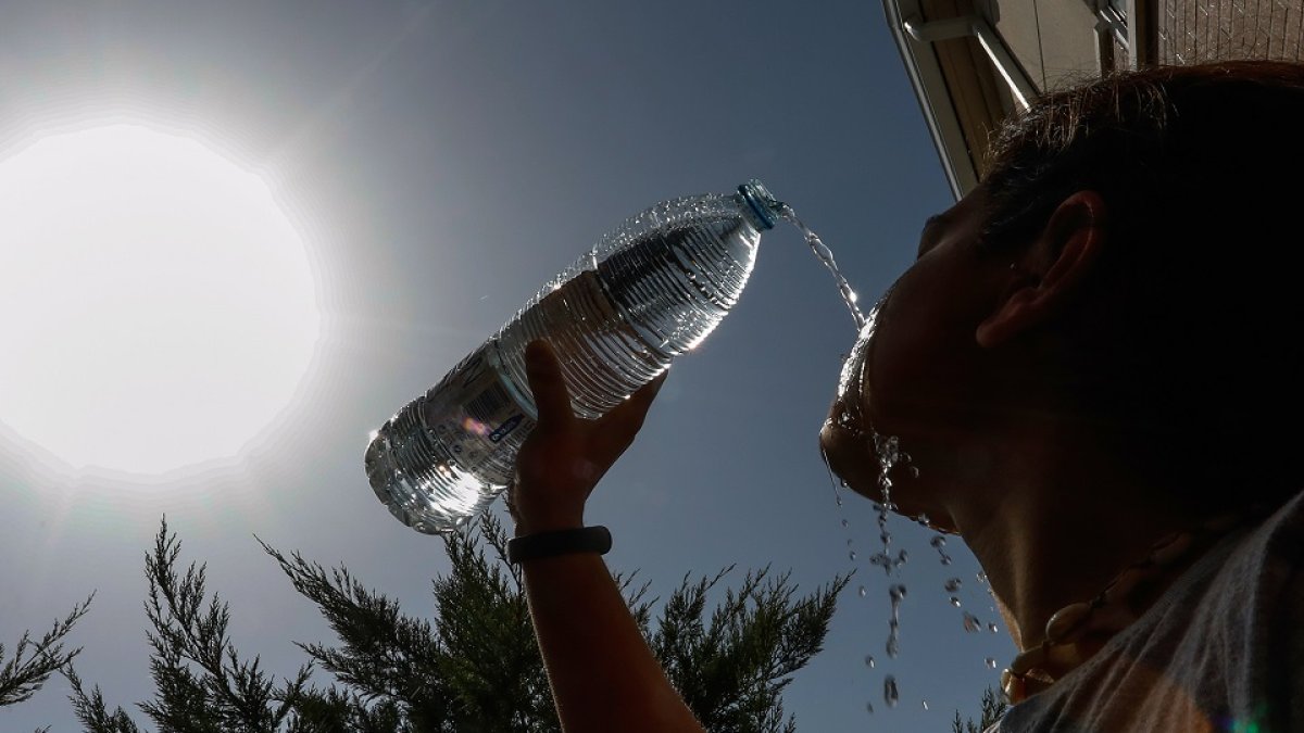 Una persona se refresca para soportair las altas temperaturas. J.M. LOSTAU
