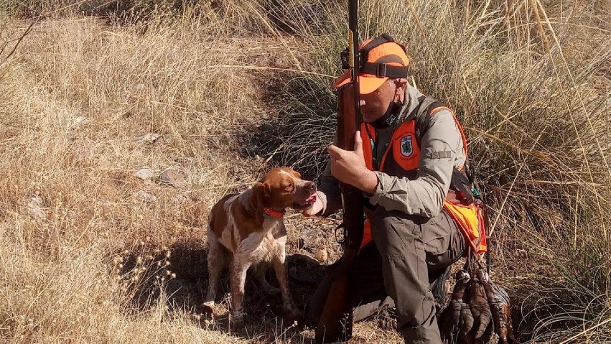 Un aficionado que acaba de cobrar una perdiz felicitando a su perro. 
 - LEONARDO DE LA FUENTE