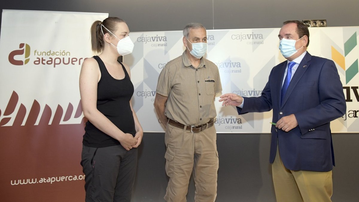 El director de Caja Viva Caja Rural de Burgos, Ramón Sobremonte (D), junto con uno de los coodirectories de los yacimiento de Atapuerca, José María Bermúdez de Castro (C), y la investigadora que recibe la beca, Cecilia García Campo (I). - ICAL