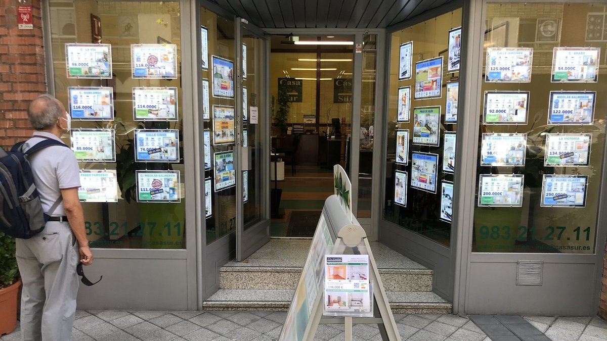 Un hombre observa los anuncios de venta y alquiler de viviendas en una inmobiliaria.- ICAL