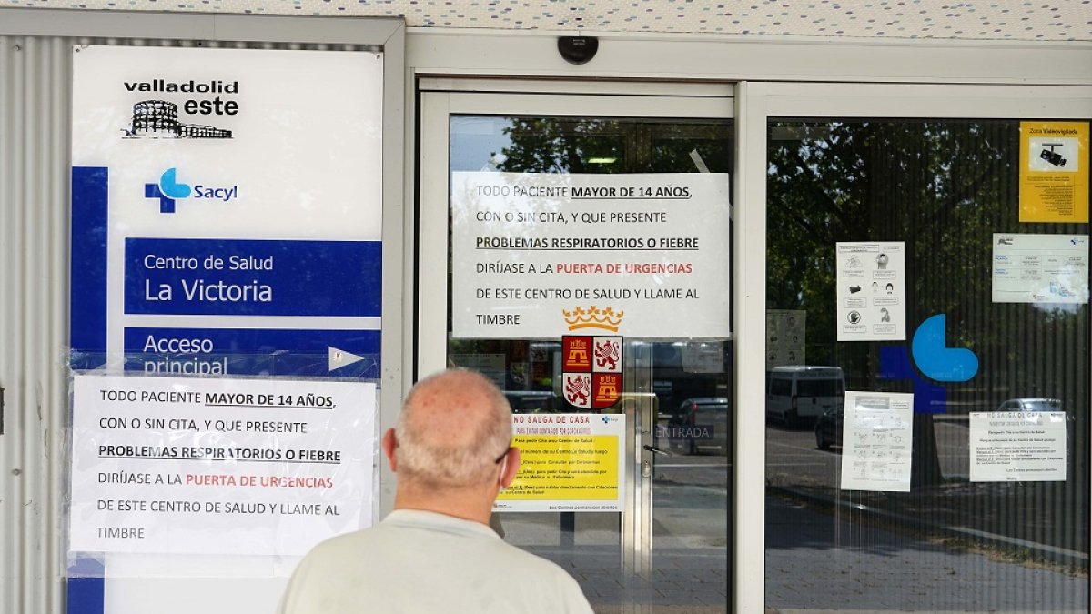 Un señor mira los carteles indicativos en la entrada de un centro de salud del barrio de La Victoria, en Valladolid. - ICAL