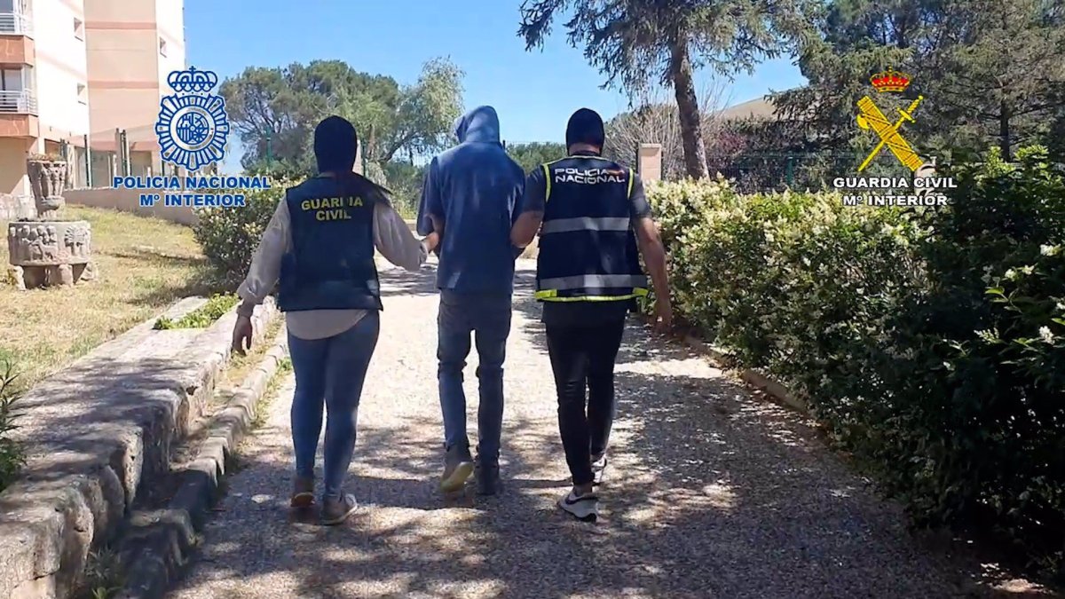 Los agentes con uno de los detenidos de la banda latina.-E.P.