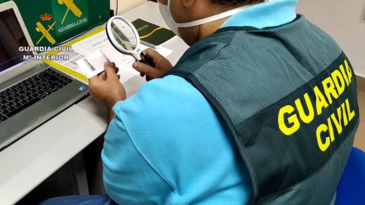 Un agente de la Guardia Civil inspecciona un carné de conducir. E.P.