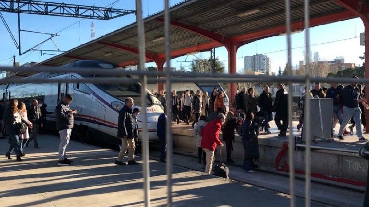 Pasajeros de Renfe cruzando las vías de Chamartín al bajarse del tren.- E. M.