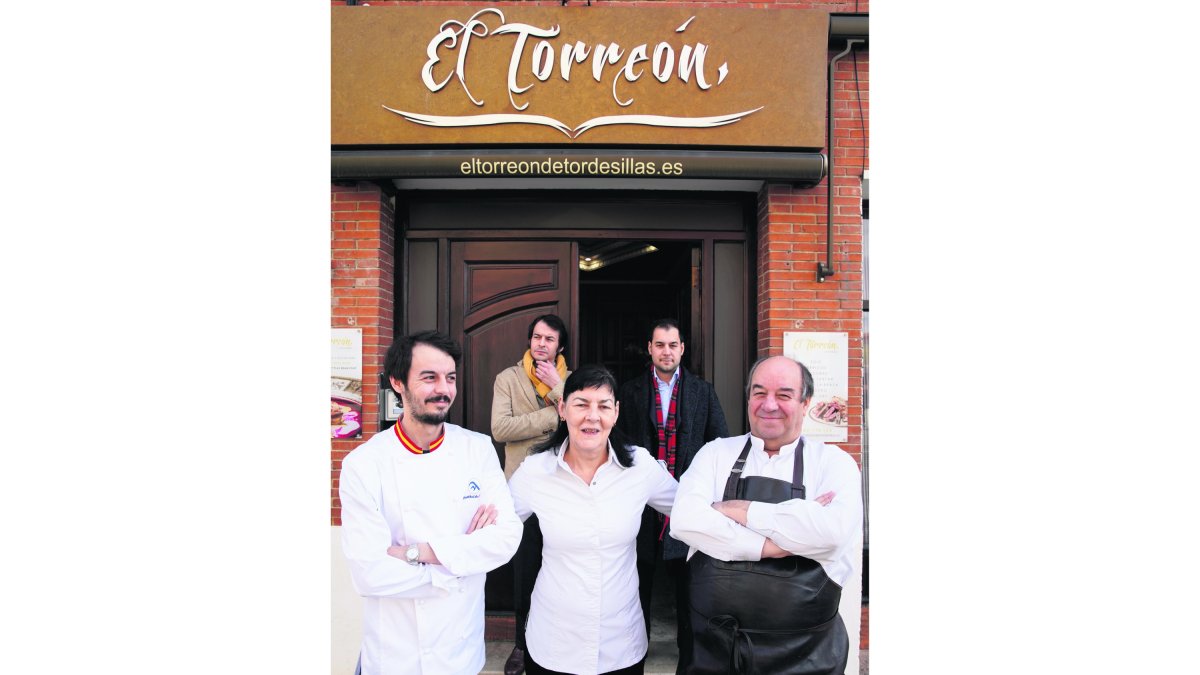 Jeremías, o ‘Jere’ para los que le conocen bien, te recibe ataviado con su coleto, su delantal de cuero al más puro estilo medieval, con el que te deleita con unas verduras frescas de su huerto, un foie fresco que según dicen, es uno de los mejores del mundo, preparado a la plancha con salsa de Oporto, pasas y arándanos. Se siente orgulloso de la palabra ‘mesonero’, un oficio al que se ha dedicado en cuerpo y alma desde hace cuarenta años de forma incansable en la Villa del Tratado.  En la imagen, junto a su mujer, Mª Ángeles y sus tres hijos (Leo, Cristóbal y Adolfo) en la puerta de este restaurante emblemático de Castilla y León. Ahora ellos tres mantienen el legado en Alquira. / JM LOSTAU