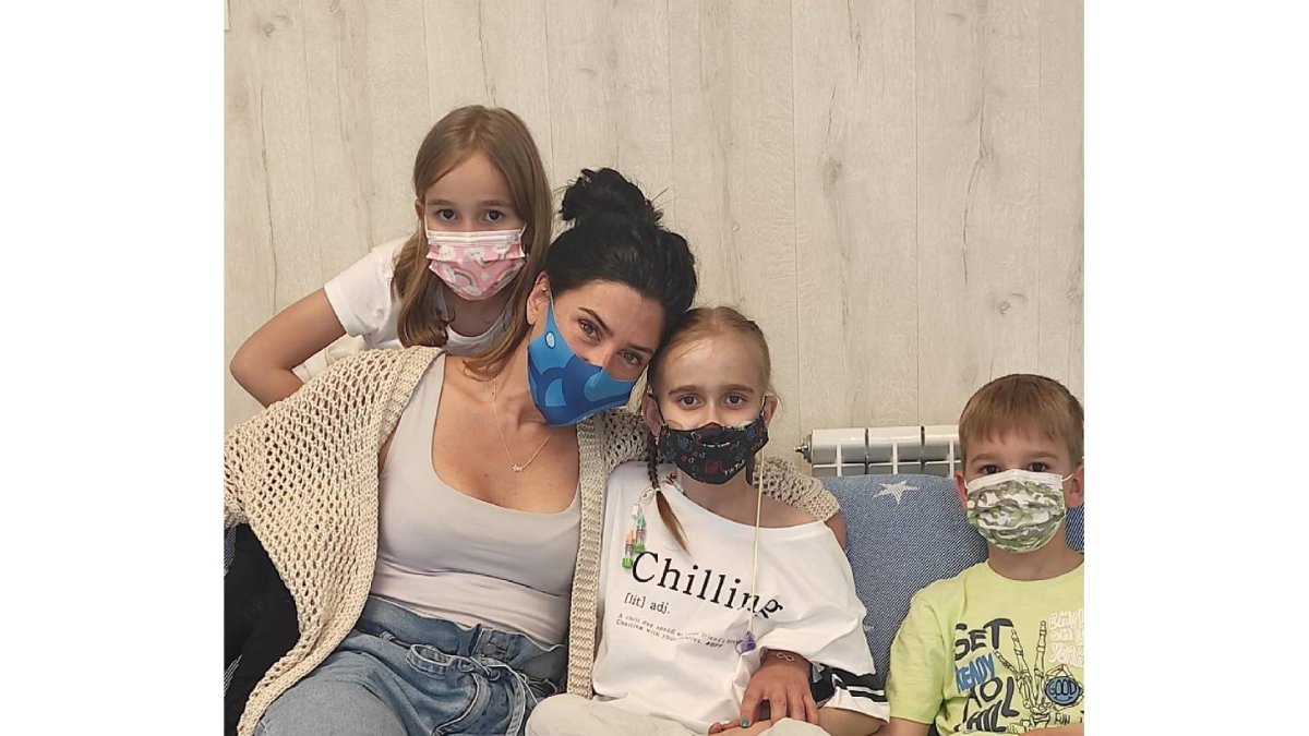Paula Luengo, con mascarilla negra, es abrazada por Alba Santos, presidenta de la asociación Somos Nupa, junto a sus dos hermanos.- E. M.