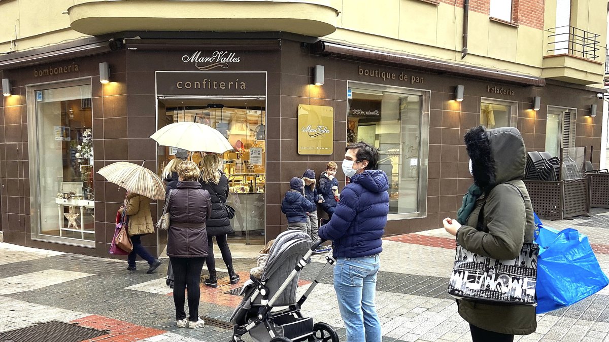 Algunos ciudadanos hacen cola ayer a la puerta de un establecimiento. J.M. LOSTAU