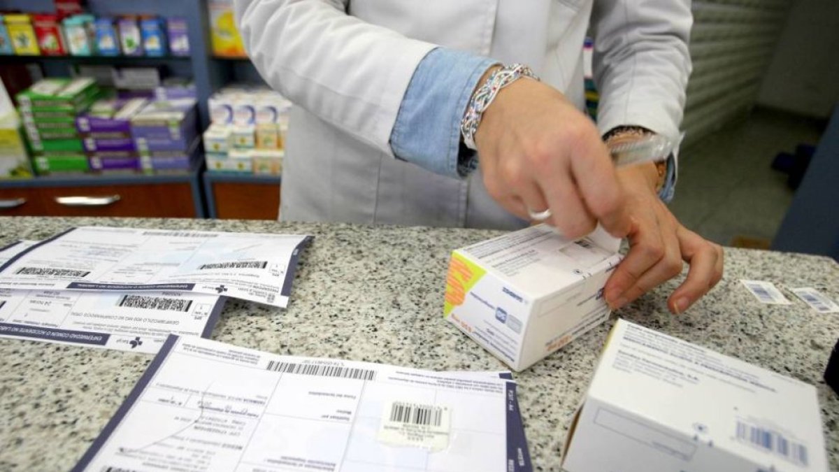 Una farmacéutica recorta el identificador del medicamento.-Ical