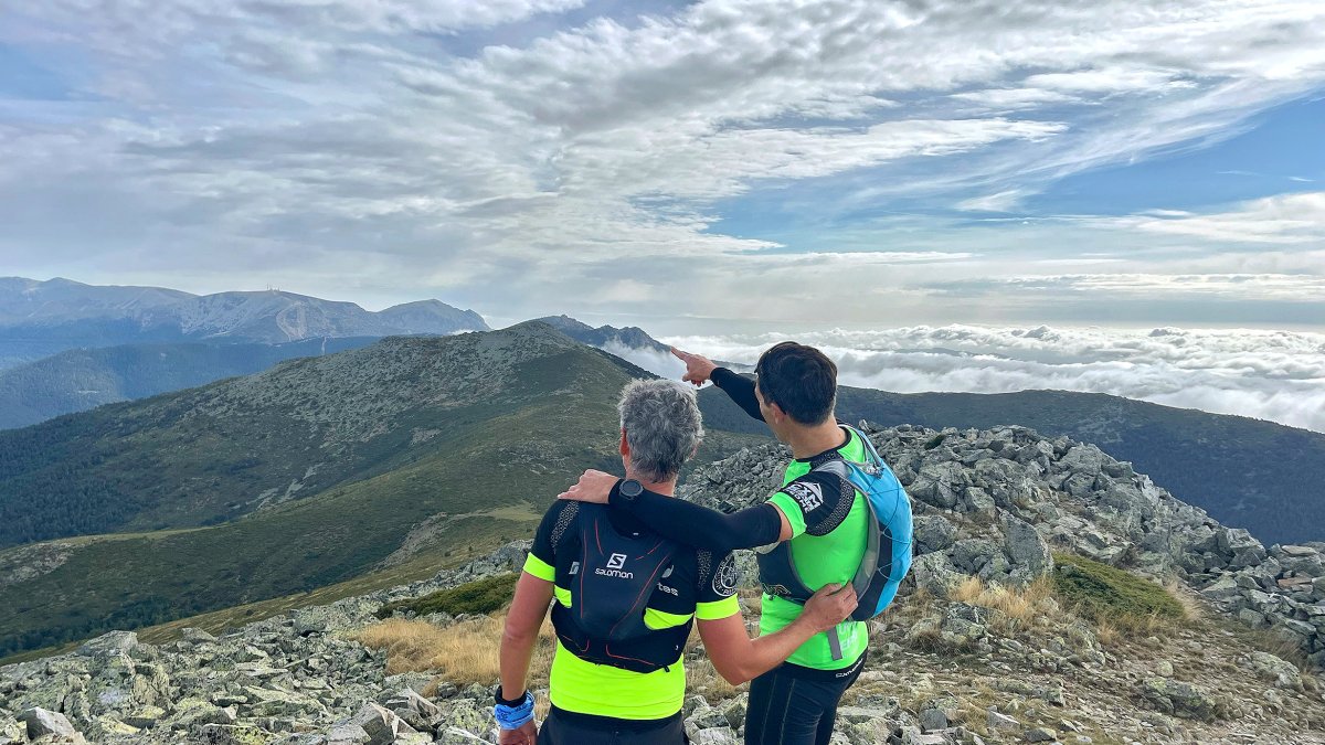Dos montañeros disfrutando de la panorámica de cumbres.