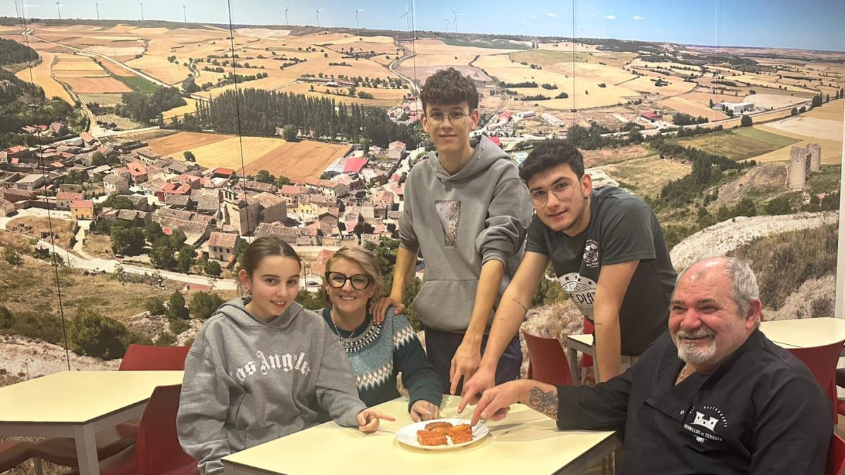 Carmen y José María con sus hijos, José y Juan, y su hija Atenea en el comedor del Bar de Hornillos delante de la panorámica del pueblo.