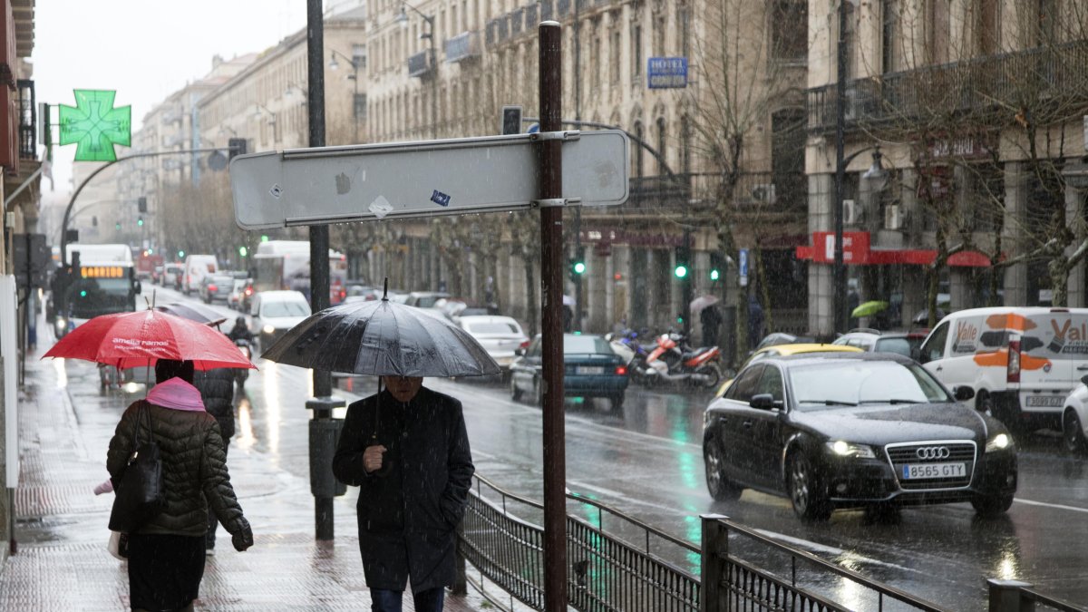 Transeúntes pasean bajo la lluvia en una imagen de archivo