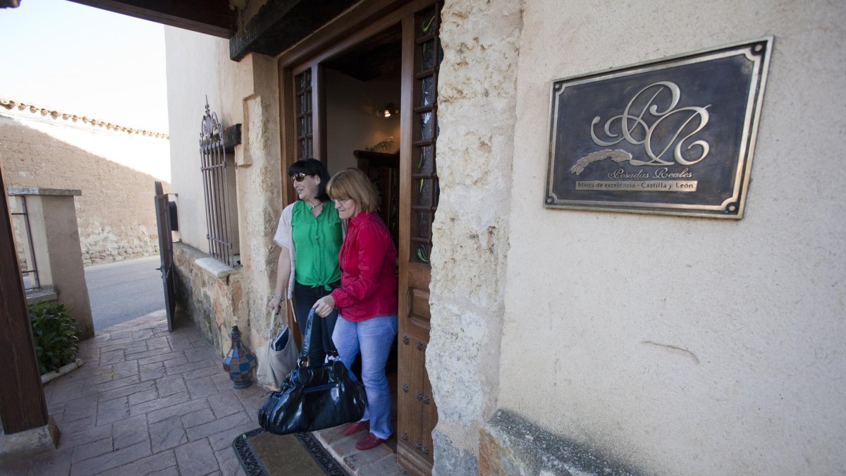 Dos turistas salen de un alojamiento rural de Castilla y León.