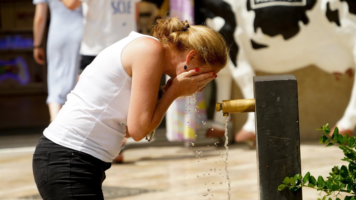 Una persona se refresca en una fuente en una imagen de archivo