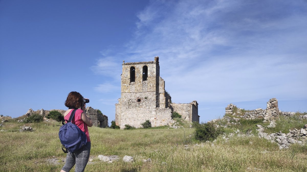 Una joven fotografía el campanario de la iglesia de San Miguel, que da buena medida de la importancia del pueblo fortificado de Peñalcázar y aún mantiene su porte.