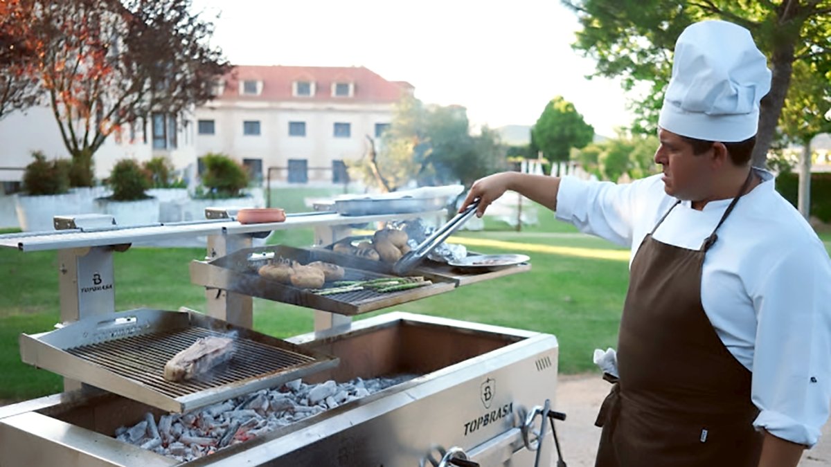 El jefe de cocina muestra una pieza en las brasas en el Jardín del Manantial