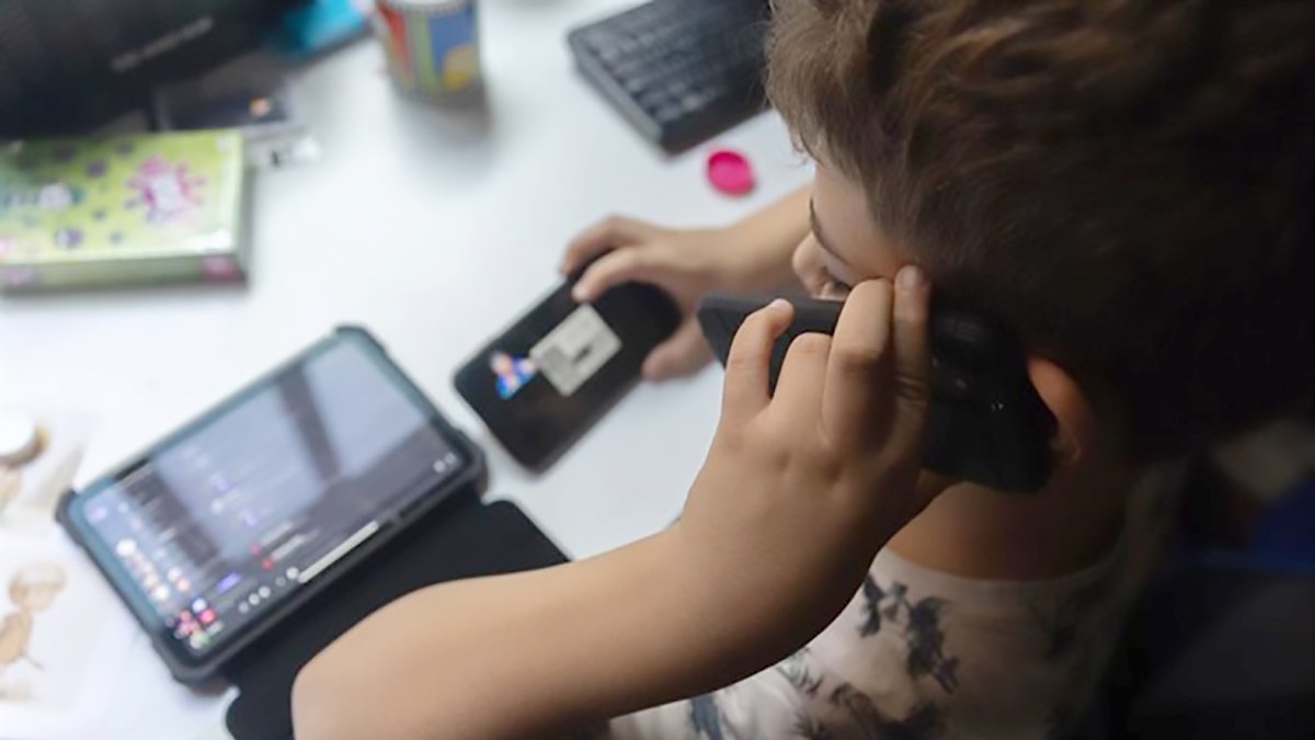 Un menor utiliza una tablet y un teléfono móvil, en una imagen de archivo.