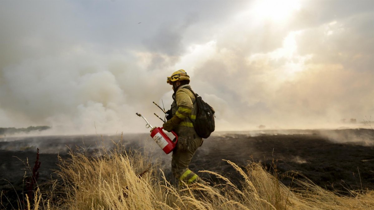 Un bombero trata de extinguir un incendio.