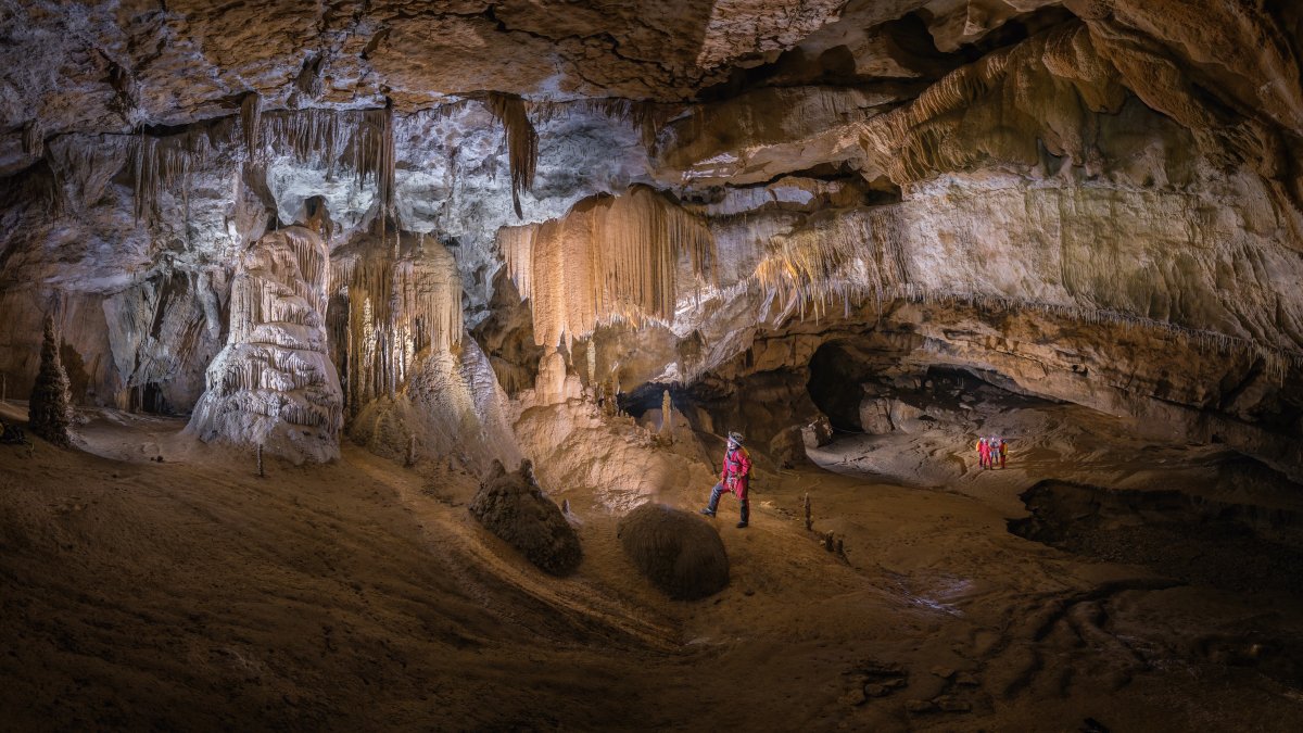 Un espeleólogo contempla la Sala del Cacique, por la que pasan los visitantes de Cueva Palomera. Abajo, acceso a la ermita de San Bernabé.