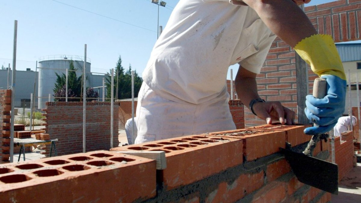 Un trabajador de la construcción levanta un muro de ladrillos en una imagen de archivo.
