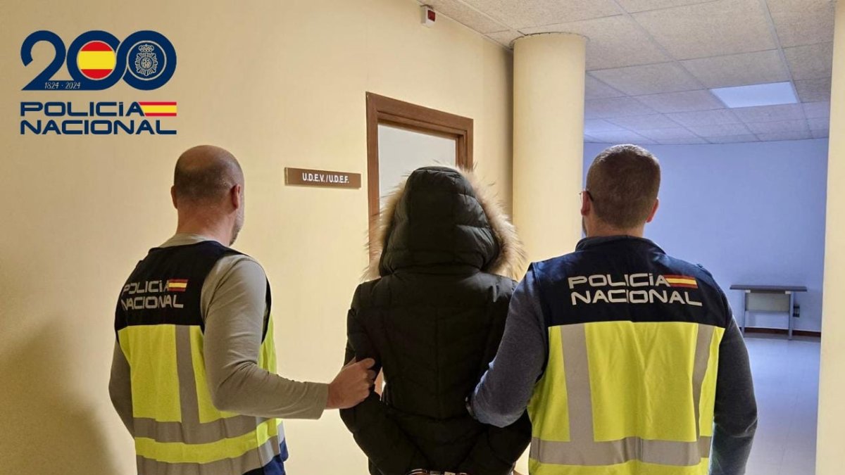 Dos agentes de la Policía Nacional deteniendo a una persona.