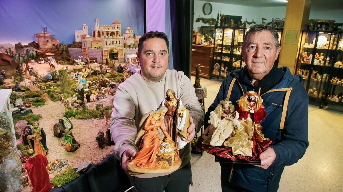 Fernando Gutiérrez y su padre muestran algunas de las piezas de su colección de 250 belenes, reunida a lo largo de los años.