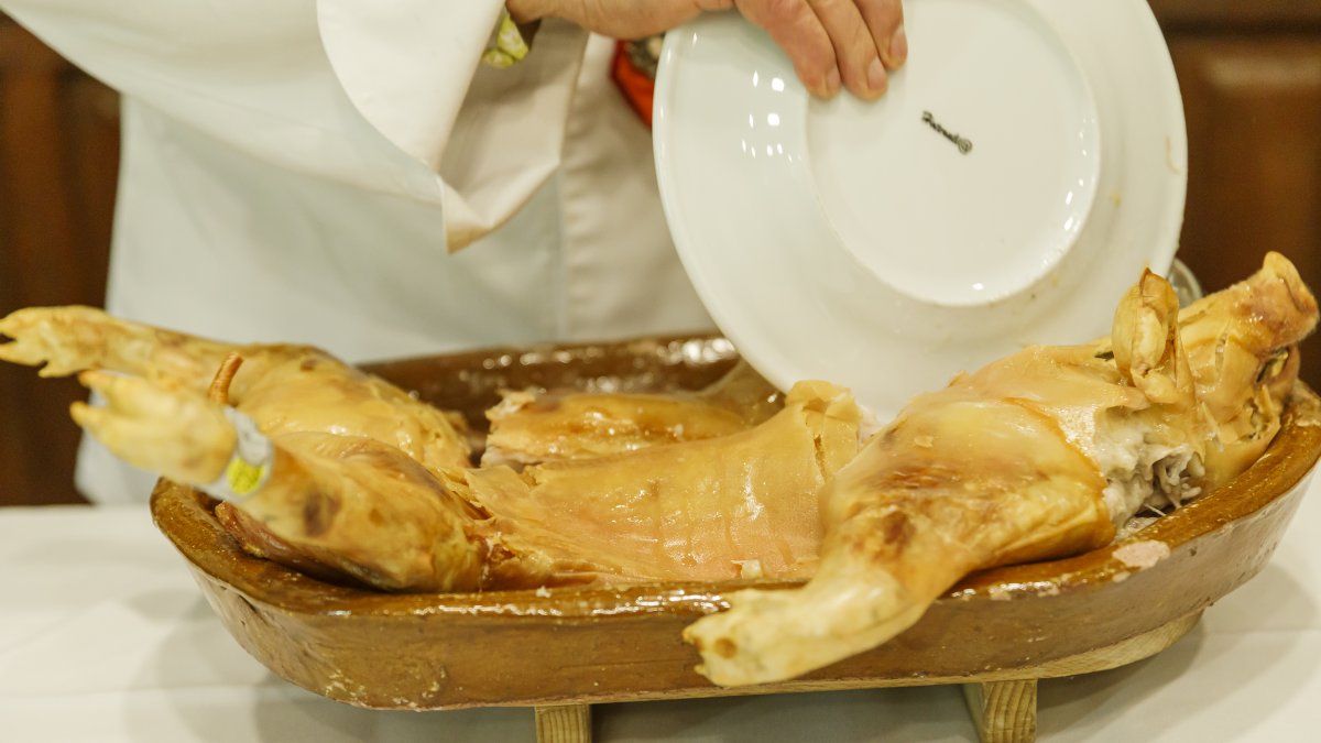 Tradicional ritual de partir el cochinillo con un plato