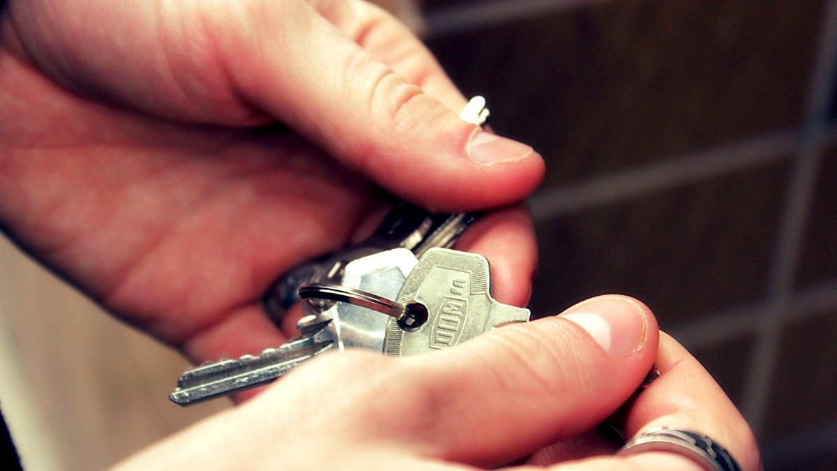 El dueño de una vivienda examina su llavero para abrir la puerta.