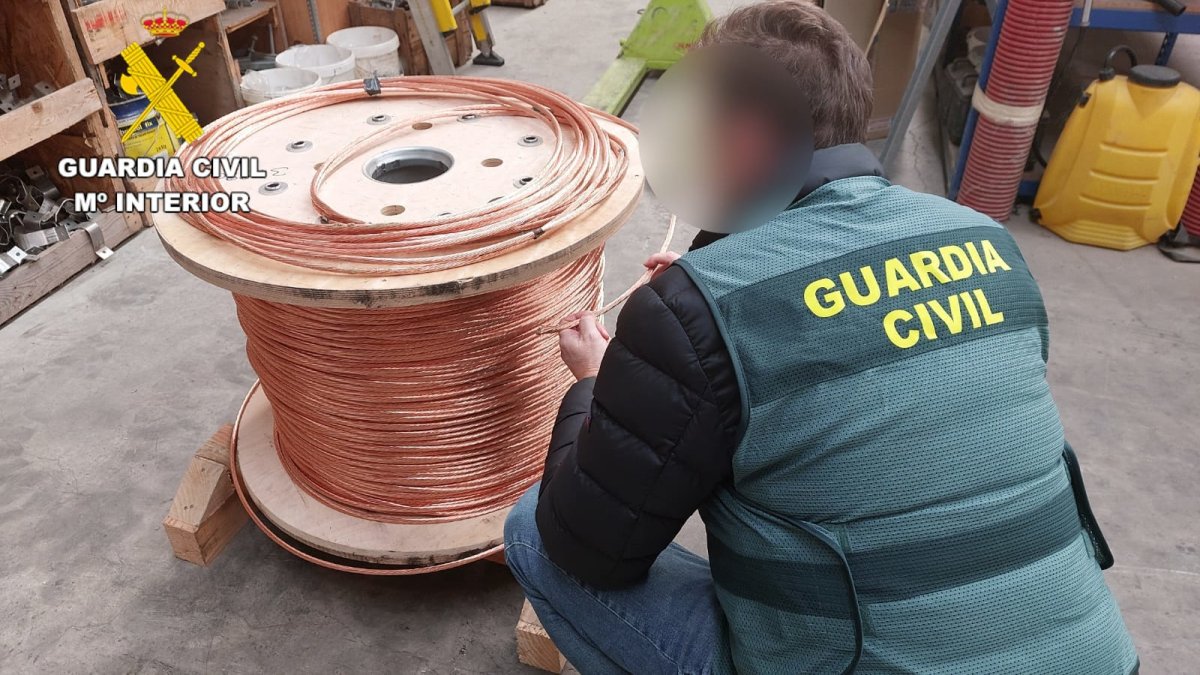 Agente de la Guardia Civil con un rollo de cobre intervenido.