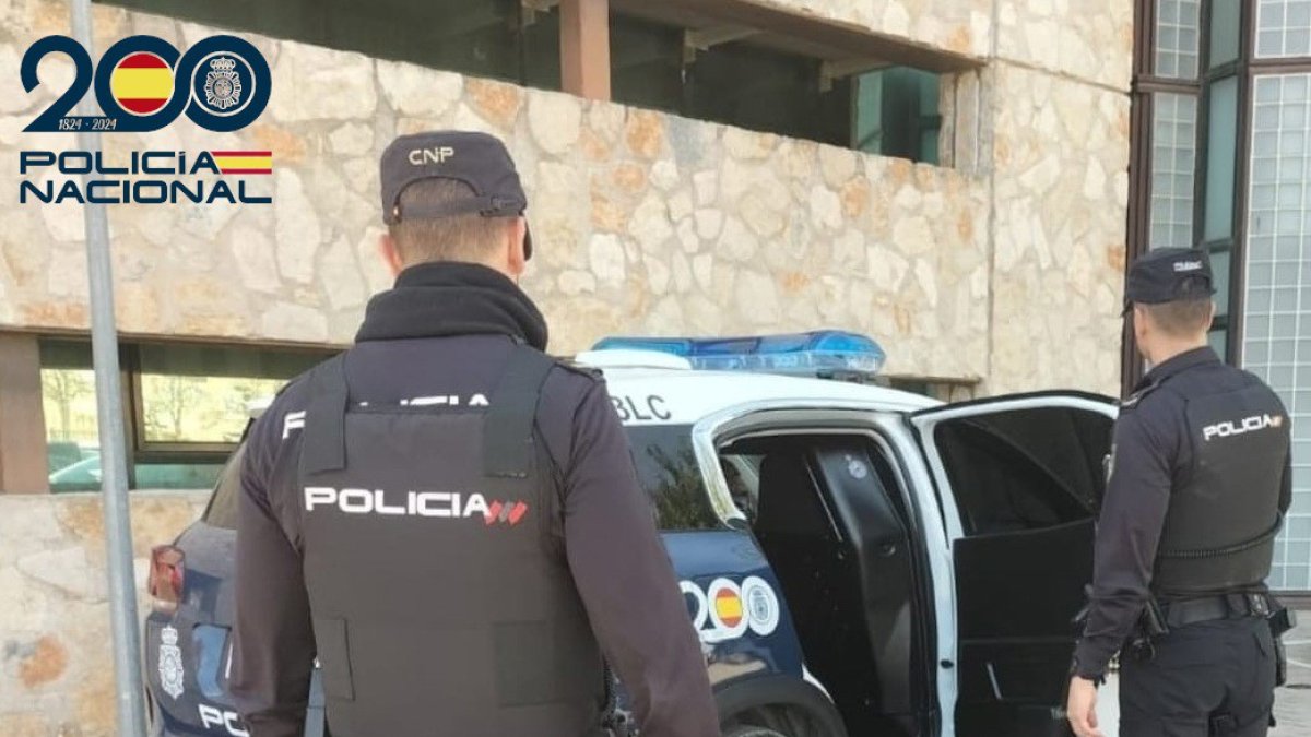 Dos agentes de la Policía Nacional, de espaldas.