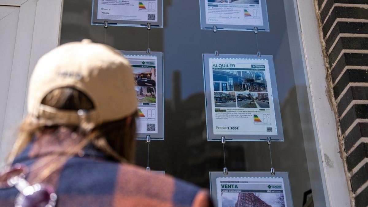 Una persona observa los anuncios en el escaparate de una inmobiliaria