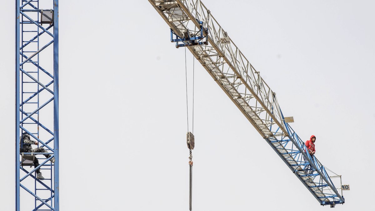 Trabajadores encaramados a una grúa en Burgos para protestar porque no les pagan.