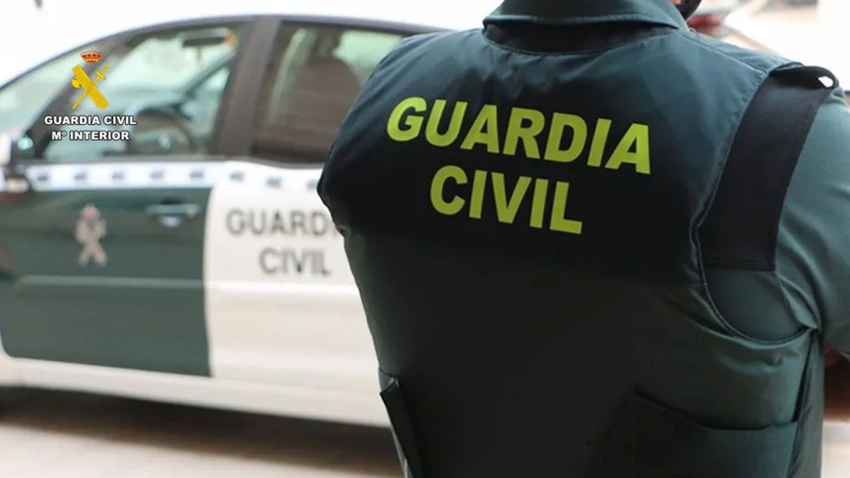 Un agente de la Guardia Civil junto a un vehículo oficial.