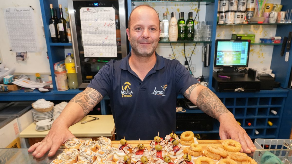 Miguel presenta desde detrás de la barra varios de los pinchos que hay en la vitrina.