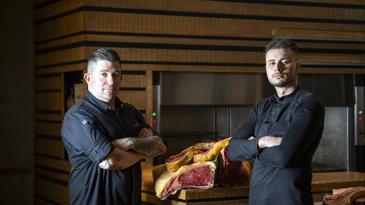 Los cocineros Guillermo Martínez de Marigorta, alma de la parrilla en Asador Abadesa, y Mario Luque, posan junto a una de las piezas de carne a las que ‘honran’.
