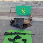 Cadáver del corzo incautado, junto al rifle y los dos visores utilizados en la caza.