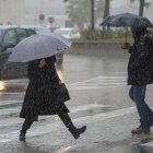 Transeúntes pasean bajo la lluvia en una imagen de archivo