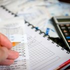 Un ciudadano calcula los gastos de su hogar con calculadora y lápiz.