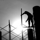 Un operario de la construcción trabaja subido a un andamio.