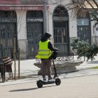 Un conductor de patinete eléctrico por la acera de Recoletos de Valladolid.