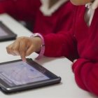 Alumnos emplean tablets en una clase.